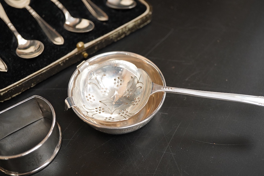 Two cased sets of six mid 20th century silver coffee spoons including Barker Brothers Silver Ltd, Birmingham, 1940, together with a silver and sterling napkin rings and a silver tea strainer on stand.